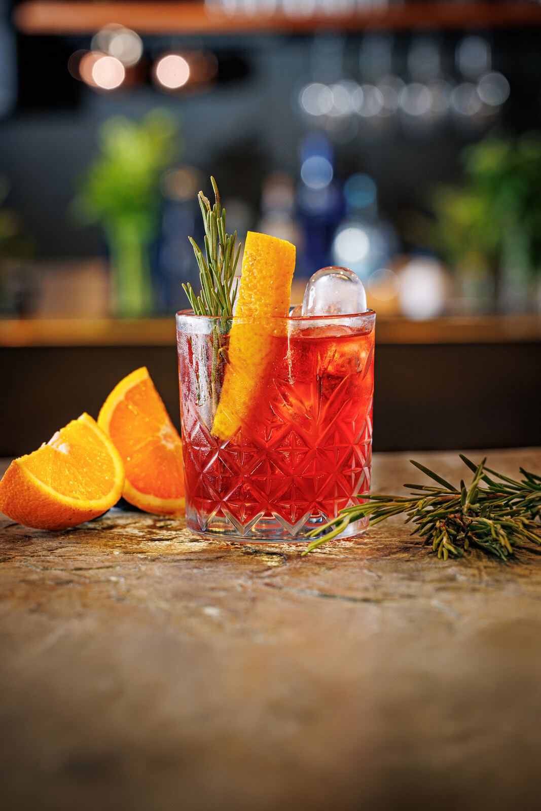 Cocktail rosso con fetta d'arancia e rosmarino